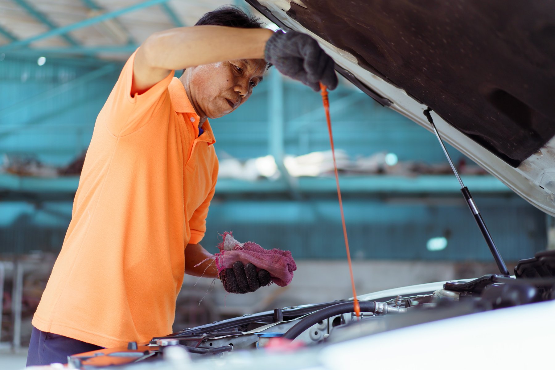 Vehicle technician inspecting an engine oil.